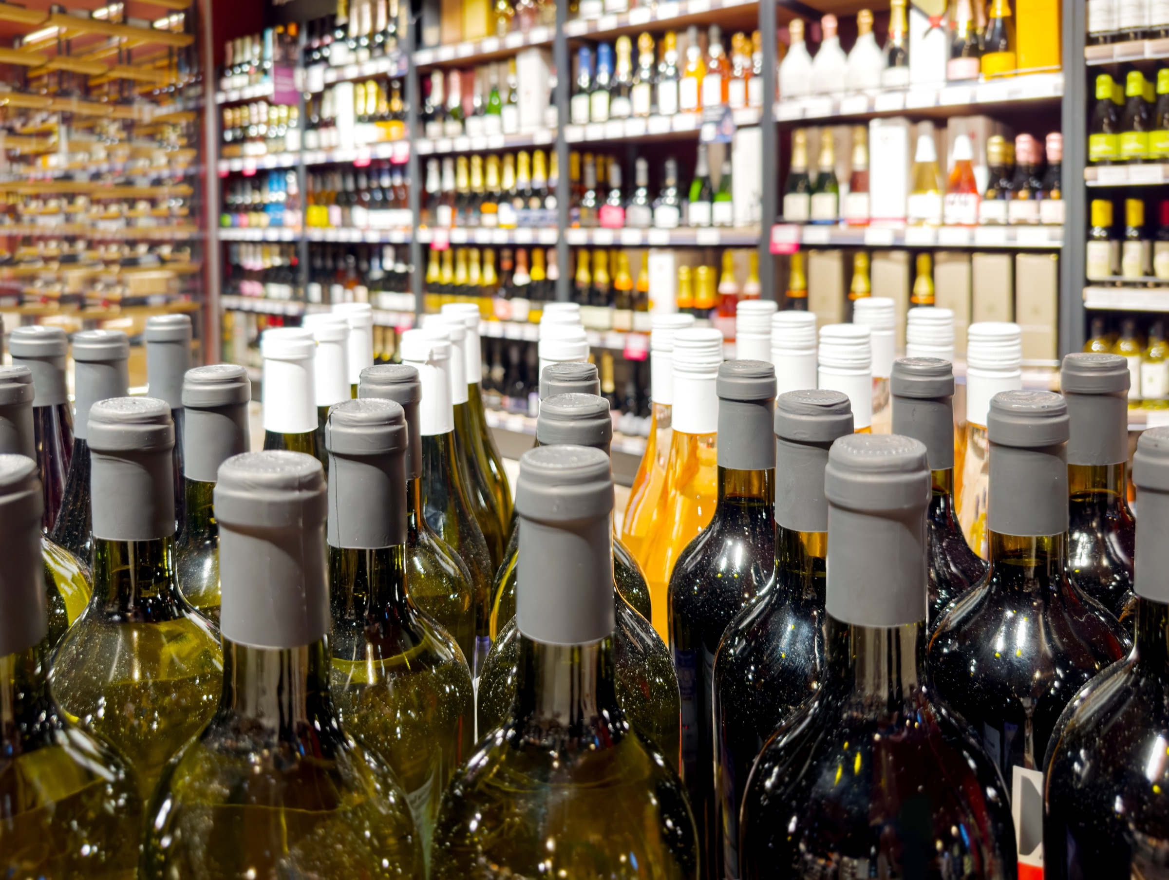 Wine bottles lined up on a liquor store shelf